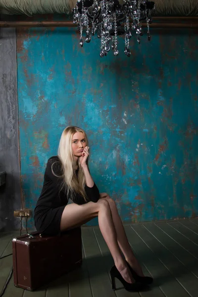 Thin, fragile blonde with a huge suitcase in an old room — Stock Photo, Image