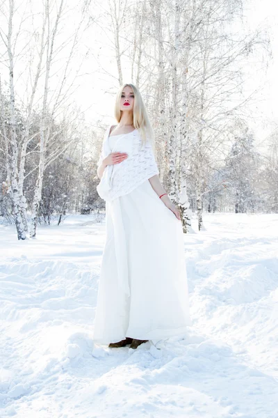 Young girl in a white dress on a background of snow-covered forest — Stock Photo, Image