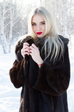 Vizon kürk orman karla kaplı bir arka plan üzerinde genç kız