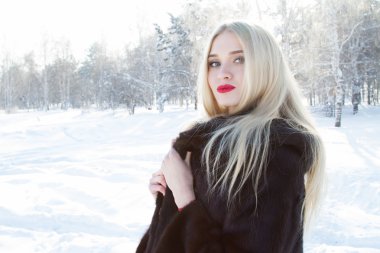 Vizon kürk orman karla kaplı bir arka plan üzerinde genç kız