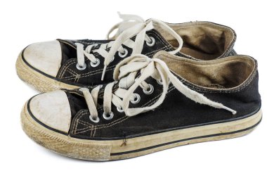 Beyaz arka planda izole edilmiş eski ve kirli spor ayakkabılar.