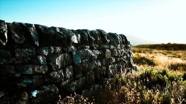 Scottish land border stone wall at sunset