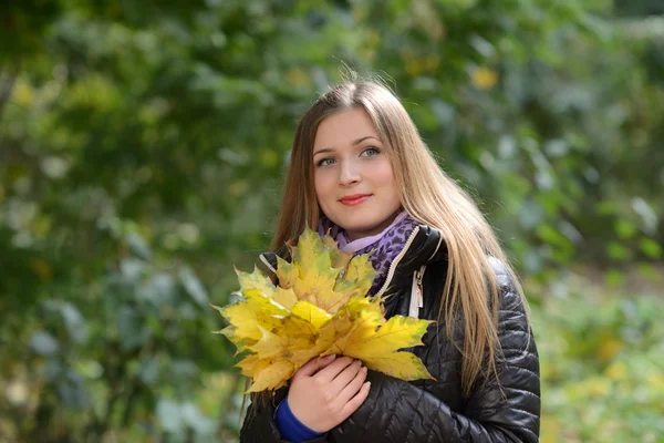 Jovem com folhas de outono na mão — Fotografia de Stock