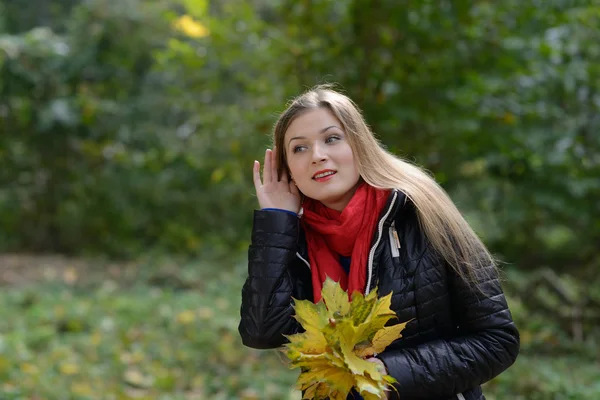 Mulher com folhas de outono na mão ouvindo fofocas — Fotografia de Stock