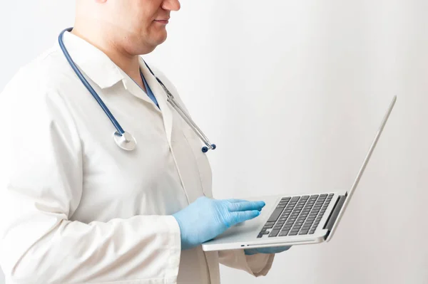 医者はノートパソコンを持っている 制服を着た医療従事者と聴診器はコンピュータ上で動作します — ストック写真