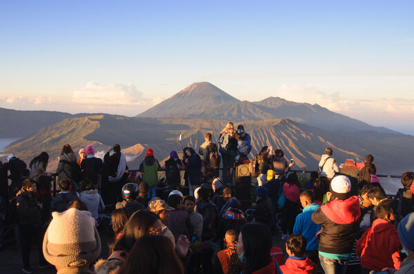 MOUNT BROMO, INDONESIA - JUNE 28, 2014: Undefined crowd of tourists watching sunrise over Bromo volcano
