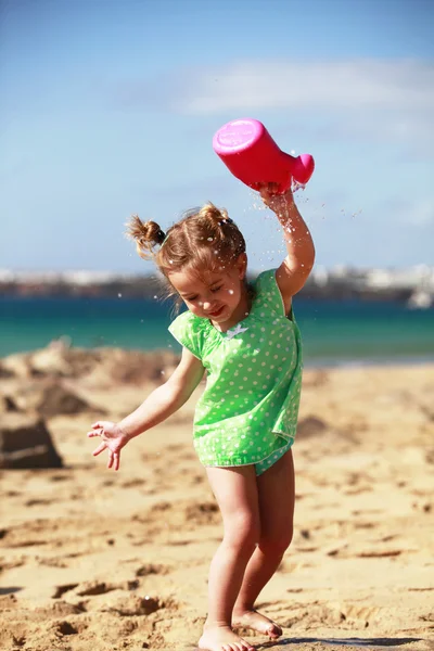 Liten flicka som leker på stranden — Stockfoto
