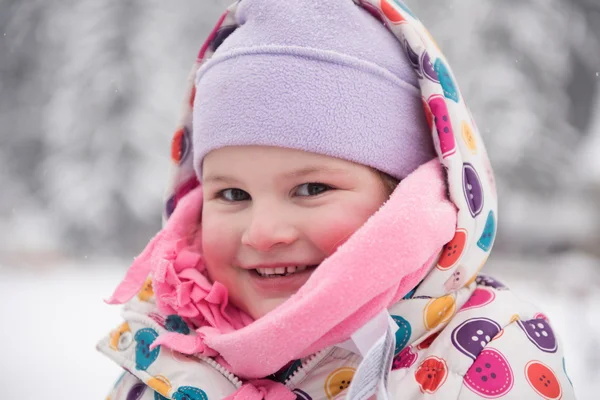 Malá holčička se bavit na zasněžené zimní den — Stock fotografie