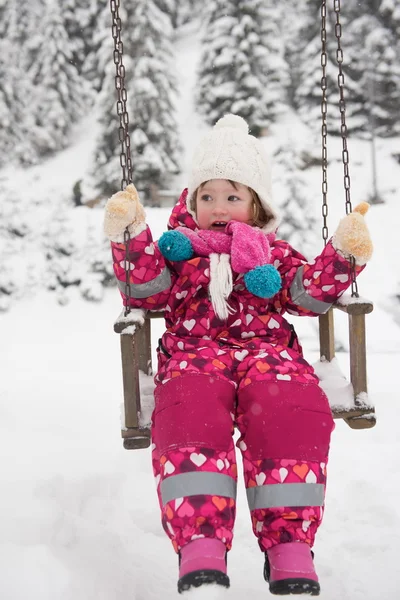 Karlı kış günü küçük kıza parkta salıncak — Stok fotoğraf