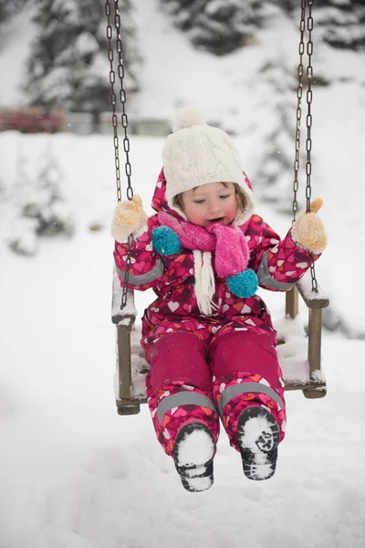 新鮮な雪 かわいい女の子のスイングと遊ぶ冬の日で公園で屋外子 — ストック写真