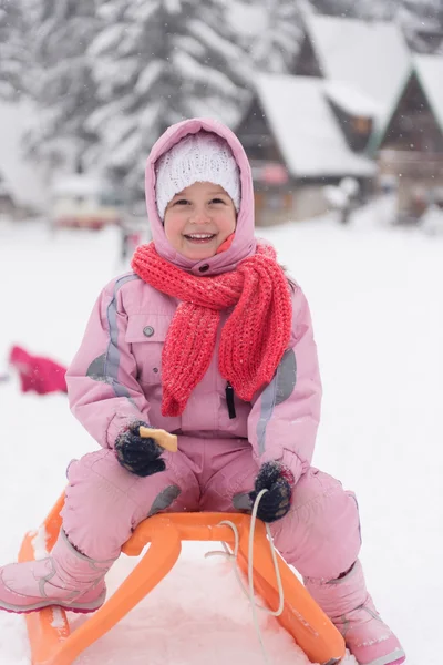 Little girl sitting on sledges — Stock Photo, Image