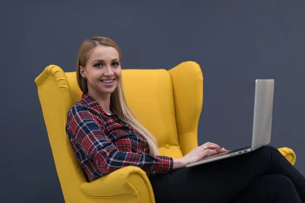 Negócio de inicialização, mulher trabalhando no laptop e sentado no amarelo — Fotografia de Stock