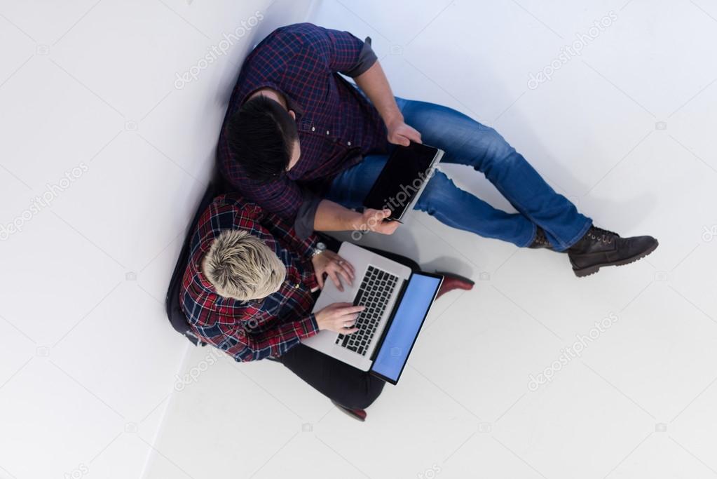 top view of  couple working on laptop computer at startup office