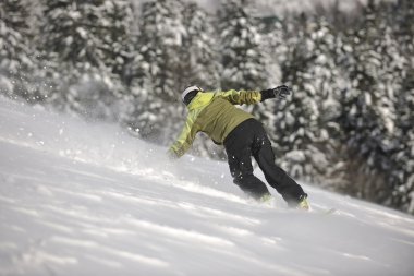 Snowboardcu kadın taze toz kar üzerinde özgürce dolaşmayı sever.