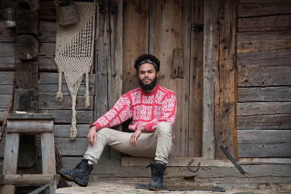 Retrato de jovem hipster na frente da casa de madeira — Fotografia de Stock