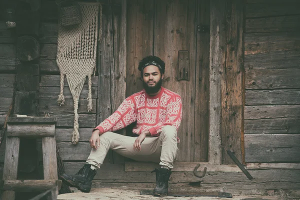 Portrait of young hipster in front of wooden house — Stock Photo, Image