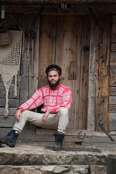 Retrato de joven hipster frente a casa de madera — Foto de Stock