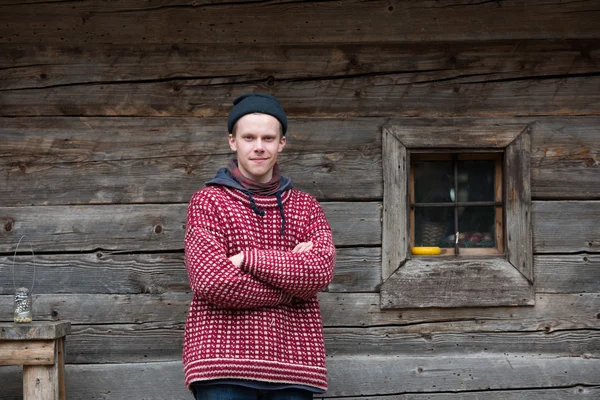 Joven hipster en frente de casa de madera — Foto de Stock