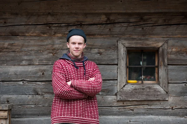 Joven hipster en frente de casa de madera —  Fotos de Stock