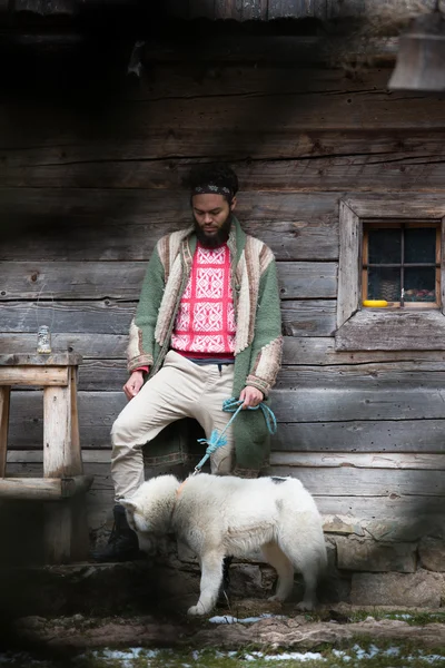Hipster s psem před dřevěný dům — Stock fotografie