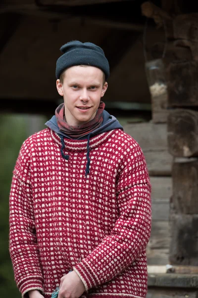 Joven hipster en frente de casa de madera — Foto de Stock