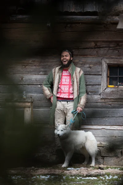 Hipster avec chien devant la maison en bois — Photo