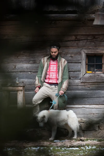 Хіпстер з собакою перед дерев'яним будинком — стокове фото