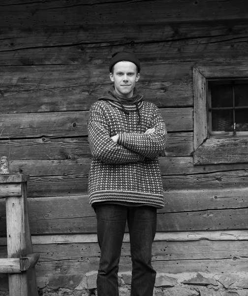 Joven hipster en frente de casa de madera — Foto de Stock