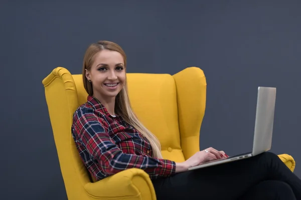 Negócio de inicialização, mulher trabalhando no laptop e sentado no amarelo — Fotografia de Stock