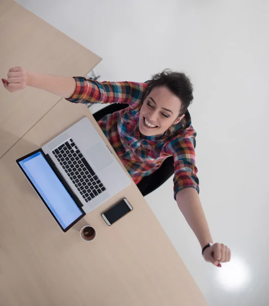 Вид сверху на молодую деловую женщину, работающую на ноутбуке — стоковое фото