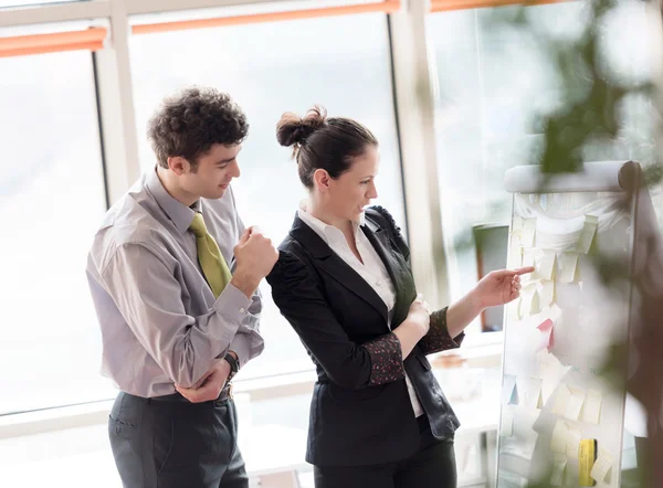 Jeune couple travaillant sur flip board au bureau — Photo