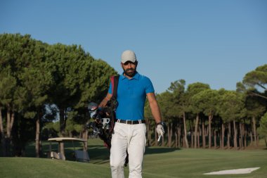 yürüyüş ve golf çantası taşıyan golfçü