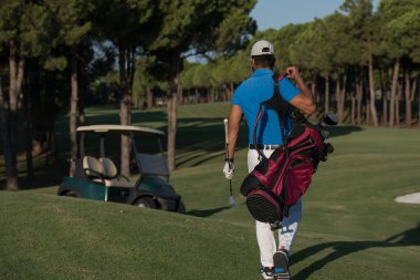 yürüyüş ve golf çantası taşıyan golfçü