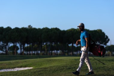yürüyüş ve güzel günbatımı golf çantası taşıyan golfçü