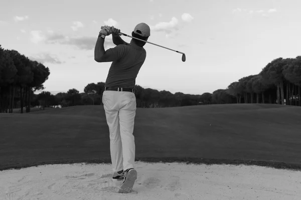 Golfista batendo um bunker de areia tiro no pôr do sol — Fotografia de Stock