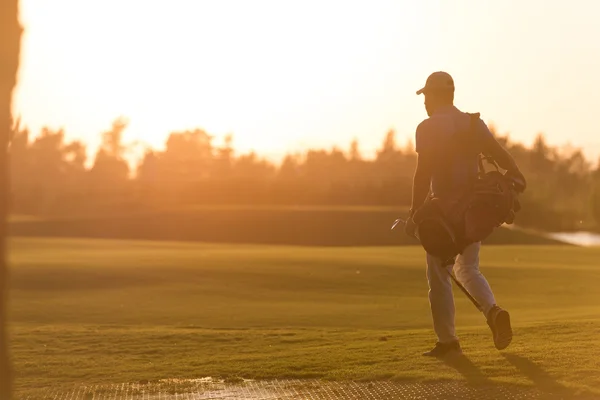 Golfozó, séta és a golf-zsák a gyönyörű naplemente — Stock Fotó