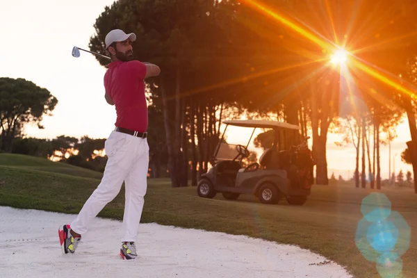 Golfista bít písečných bunkr výstřel na západ slunce — Stock fotografie