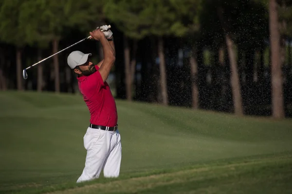 Golfista uderzanie piasku bunkra — Zdjęcie stockowe