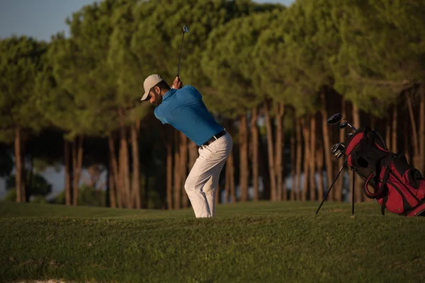 Golfista batendo um bunker de areia tiro no pôr do sol — Fotografia de Stock