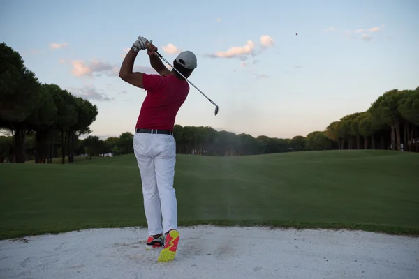 Golfista golpeando un tiro bunker de arena en la puesta del sol —  Fotos de Stock