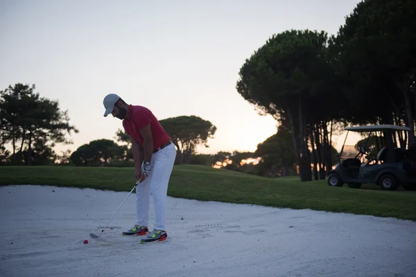 Golfista batendo um bunker de areia tiro no pôr do sol — Fotografia de Stock