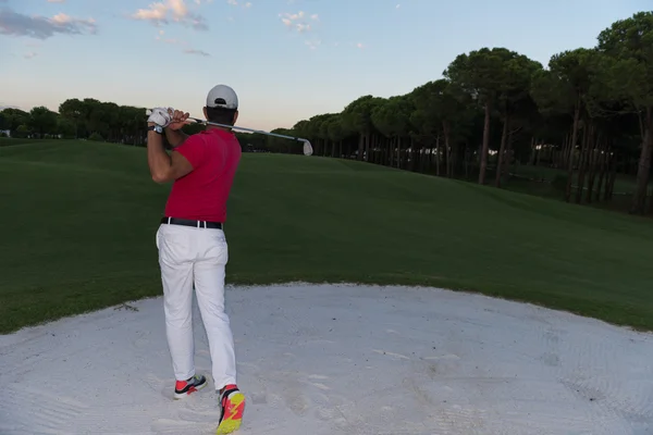 Golfista colpire un bunker di sabbia colpo al tramonto — Foto Stock