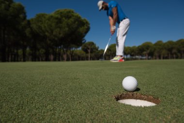 golf oyuncu vurdu, top deliğin kenarında isabet