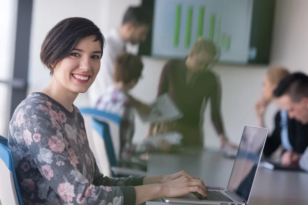 Giovane donna d'affari in ufficio che lavora su laptop con team su di me — Foto Stock