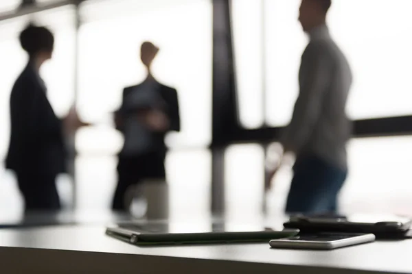Närbild på tablett, affärsmän på mötet i bakgrunden — Stockfoto
