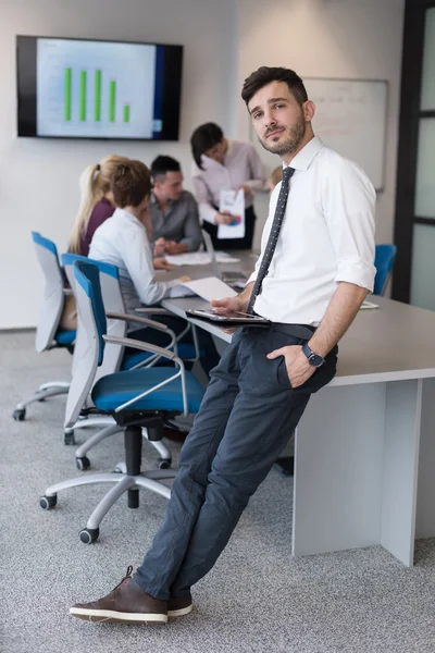 Νεαρός επιχειρηματίας με tablet στο γραφείο, αίθουσα συνεδριάσεων — Φωτογραφία Αρχείου