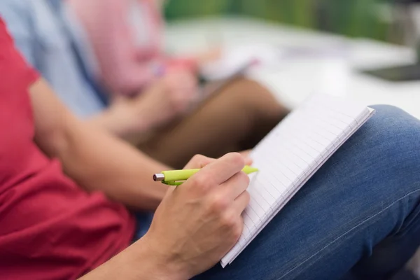 Male student taking notes in classroom — Stock Photo, Image