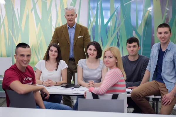 Portrait of  teacher with students group in background — Stock Photo, Image