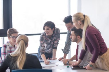 Genç iş adamları modern ofiste toplanıyor.