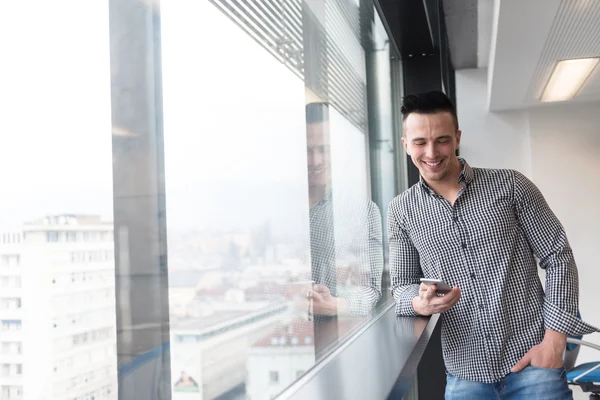 Giovane uomo d'affari utilizzando smart phone in ufficio — Foto Stock